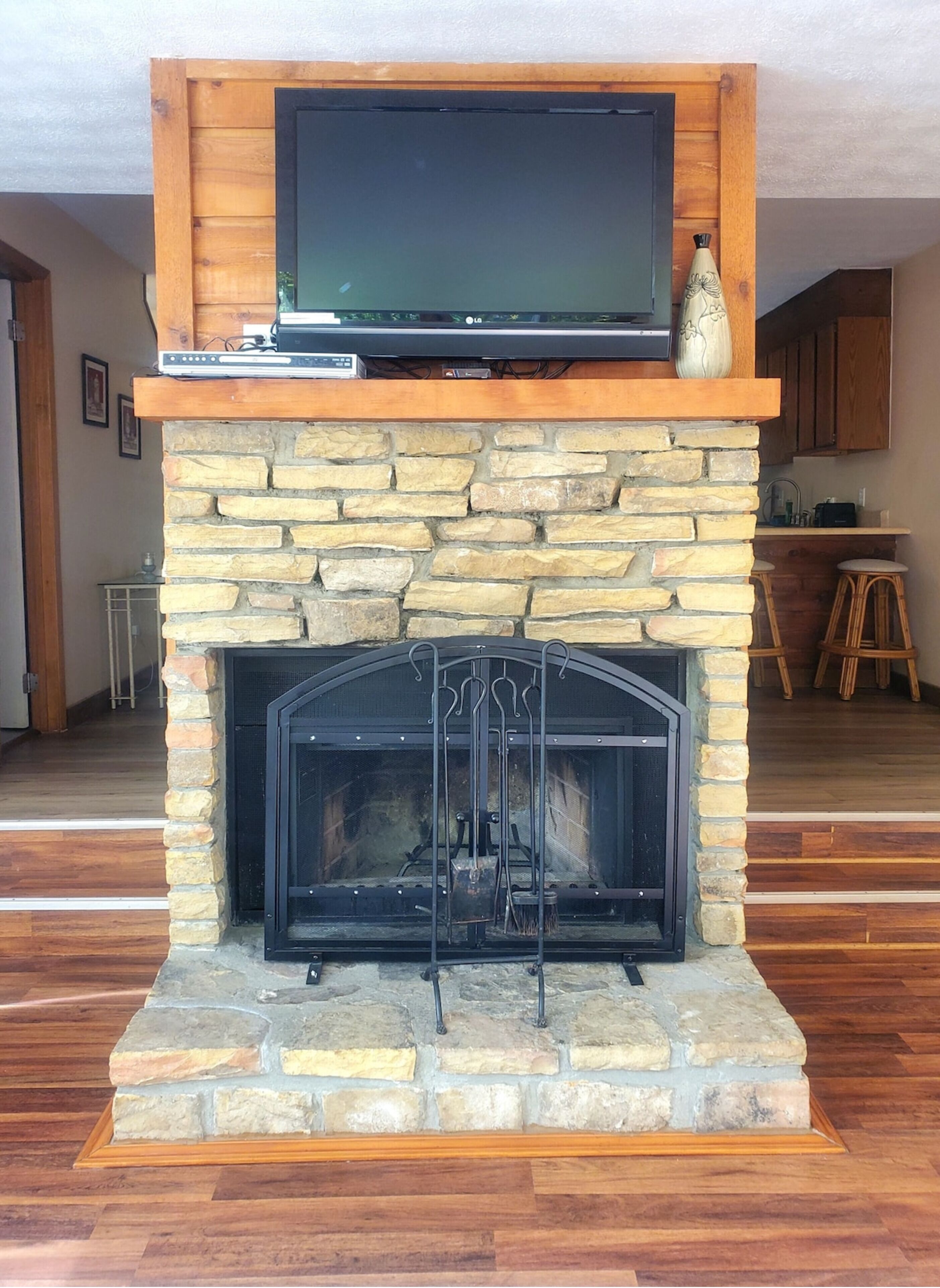 Una chimenea de piedra con un televisor de pantalla plana montado encima.