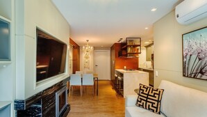 A modern living room with a fireplace, a dining area, and a kitchen. - Beautiful 2 Bedroom Apartment in Canela Dal207 (Canela)