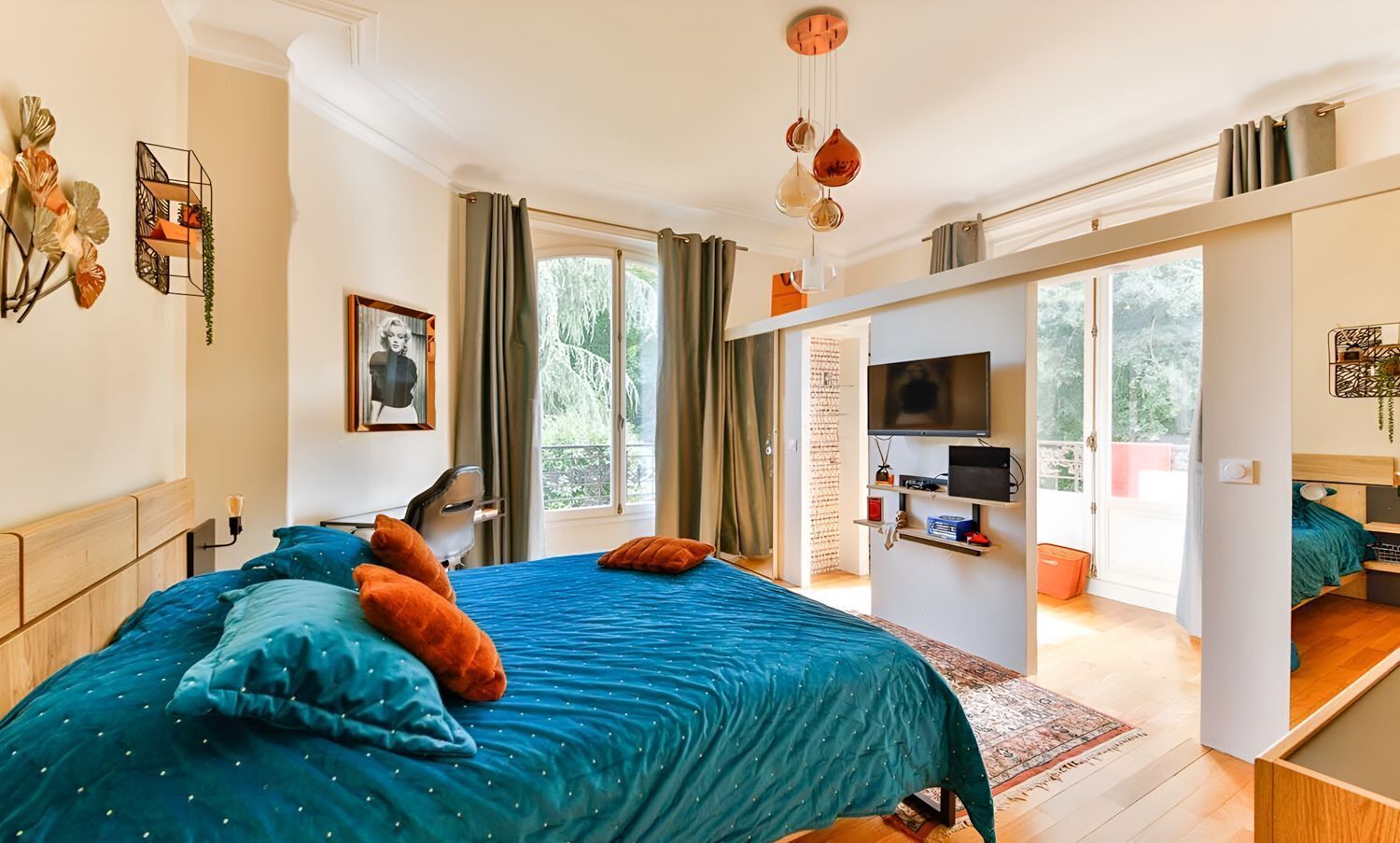 Une chambre avec un grand lit, une télévision et un balcon.