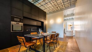 A modern kitchen with a dining area, featuring a large table, chairs, and a built-in oven. - Skylife Cimarra - Three Bedroom Villa, Sleeps 6 (Rome)