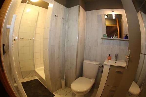 Ein Badezimmer mit Dusche, Toilette und Waschbecken.