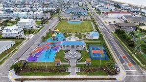 A residential area with a central park, playground, and a road with a traffic island. - 5 BR in Desired Neighborhood with Pool & Steps from Beach! By Williamson Realty (Ocean Isle Beach)