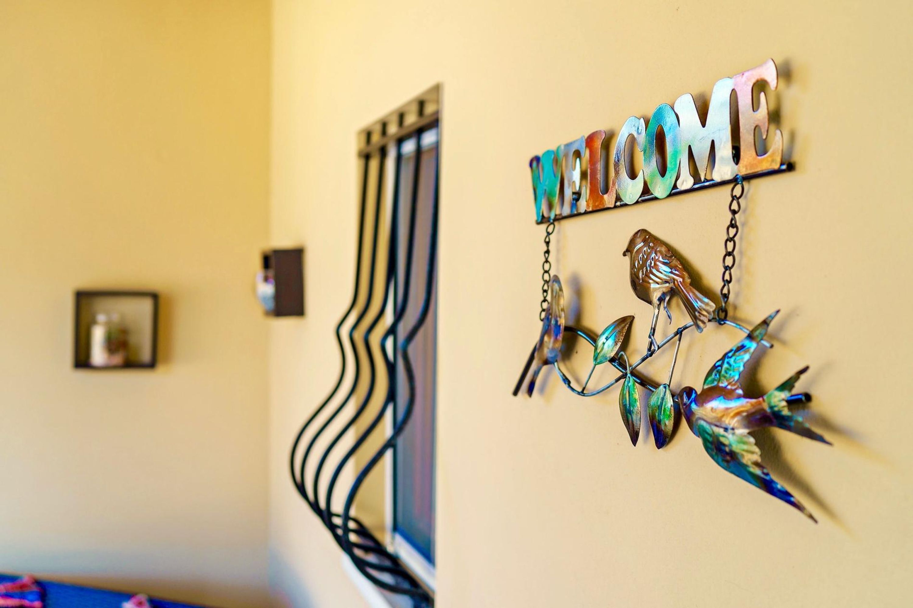 A wall with a 'WELCOME' sign and decorative metal birds.