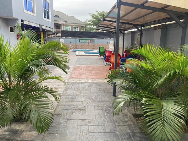 A covered outdoor area with a pool, seating, and a Heineken sign.