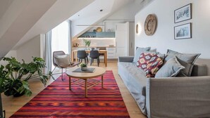 Un salon moderne avec un canapé, une table basse et, au fond, un coin repas.