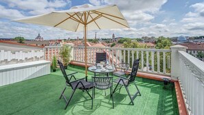 A rooftop terrace with a round table and chairs, a large umbrella, and a view of the cityscape. - Domillion 3bdr Rooftop Terrace, AC, P369 (Vilnius)