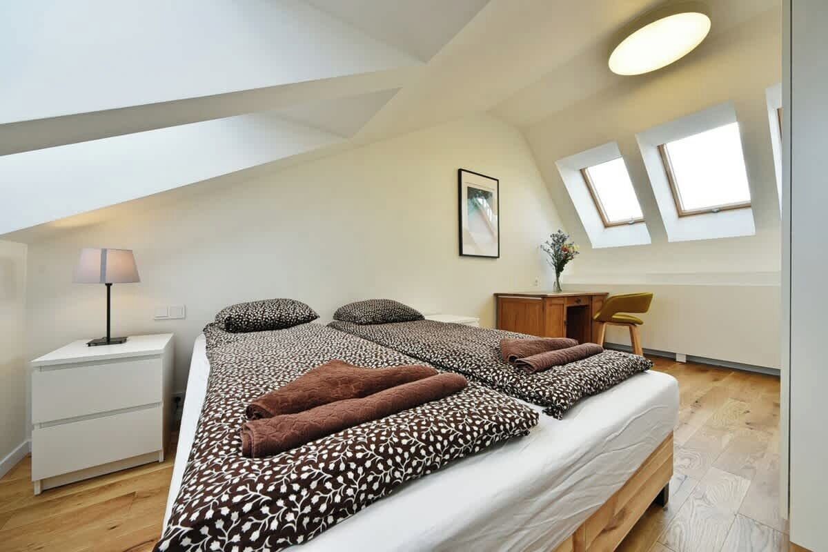 A bedroom with two beds, a desk, and a chair.