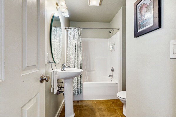 A bathroom with a white sink, mirror, and bathtub. - 4BR | Pool | Hot Tub | Game Room | Balcony (Corolla)