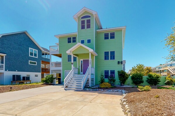 A two-story house with a front porch and a staircase leading to the entrance.