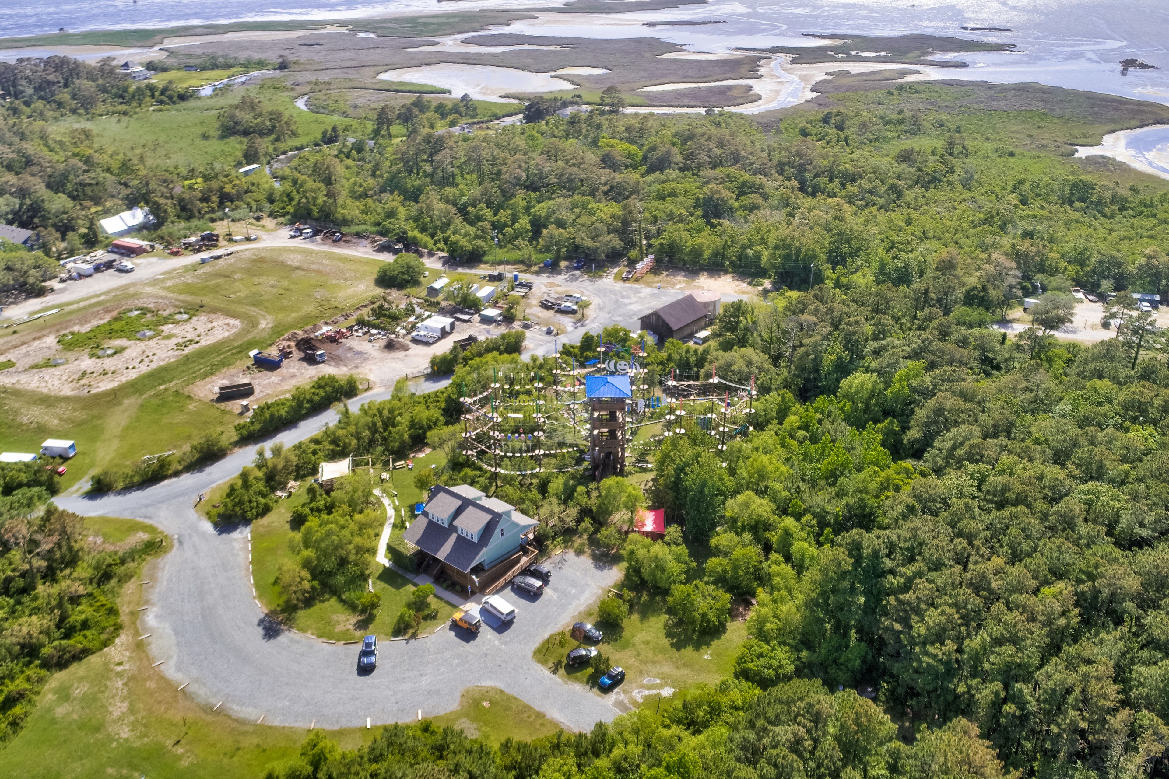Oversigtsbillede af et resort med en snoet vej, flere bygninger og et stort vandomraade i baggrunden.