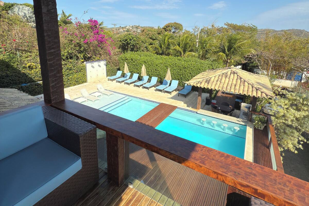 A pool area with lounge chairs and a wooden deck.
