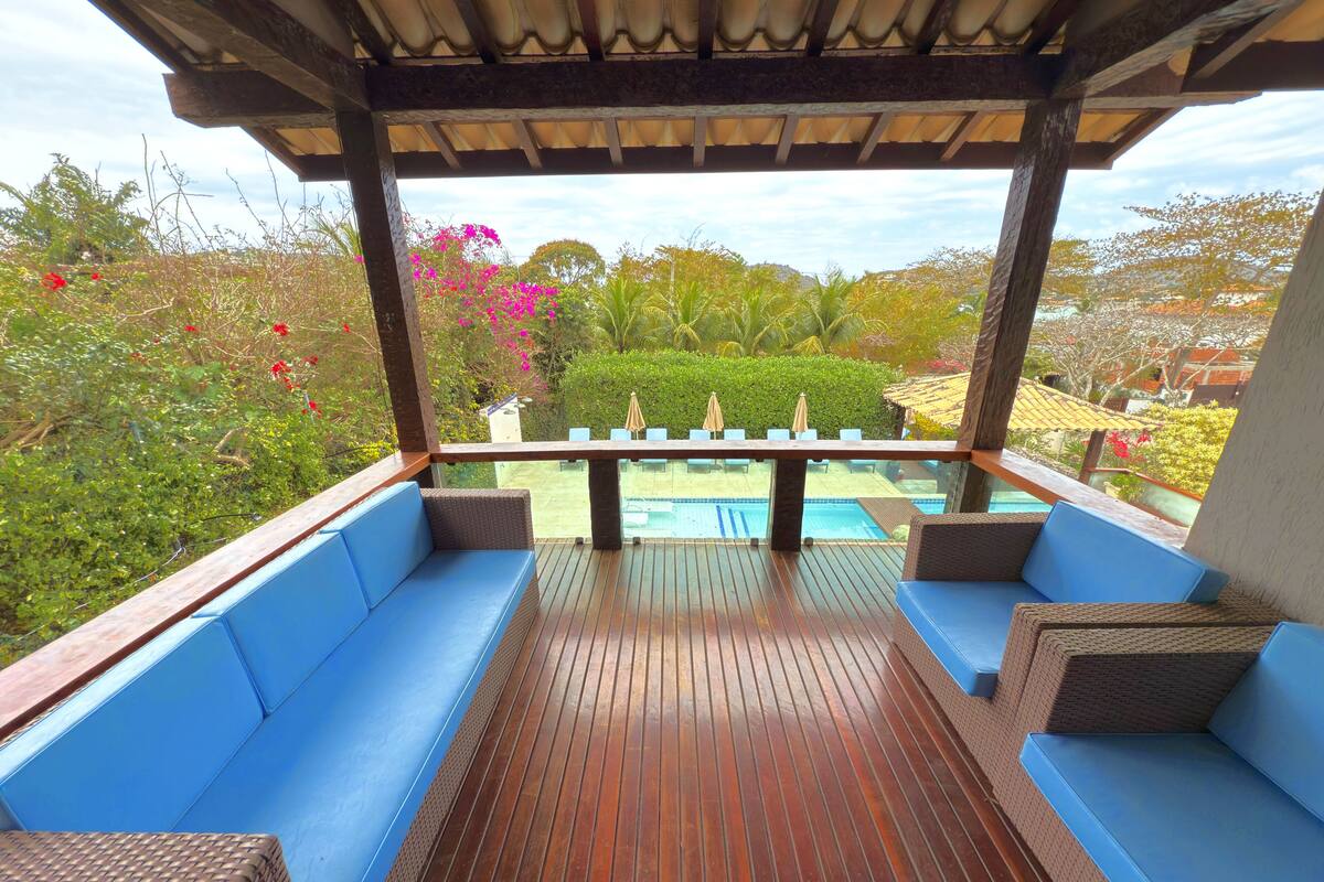 A covered outdoor seating area with blue cushioned benches and a wooden deck.