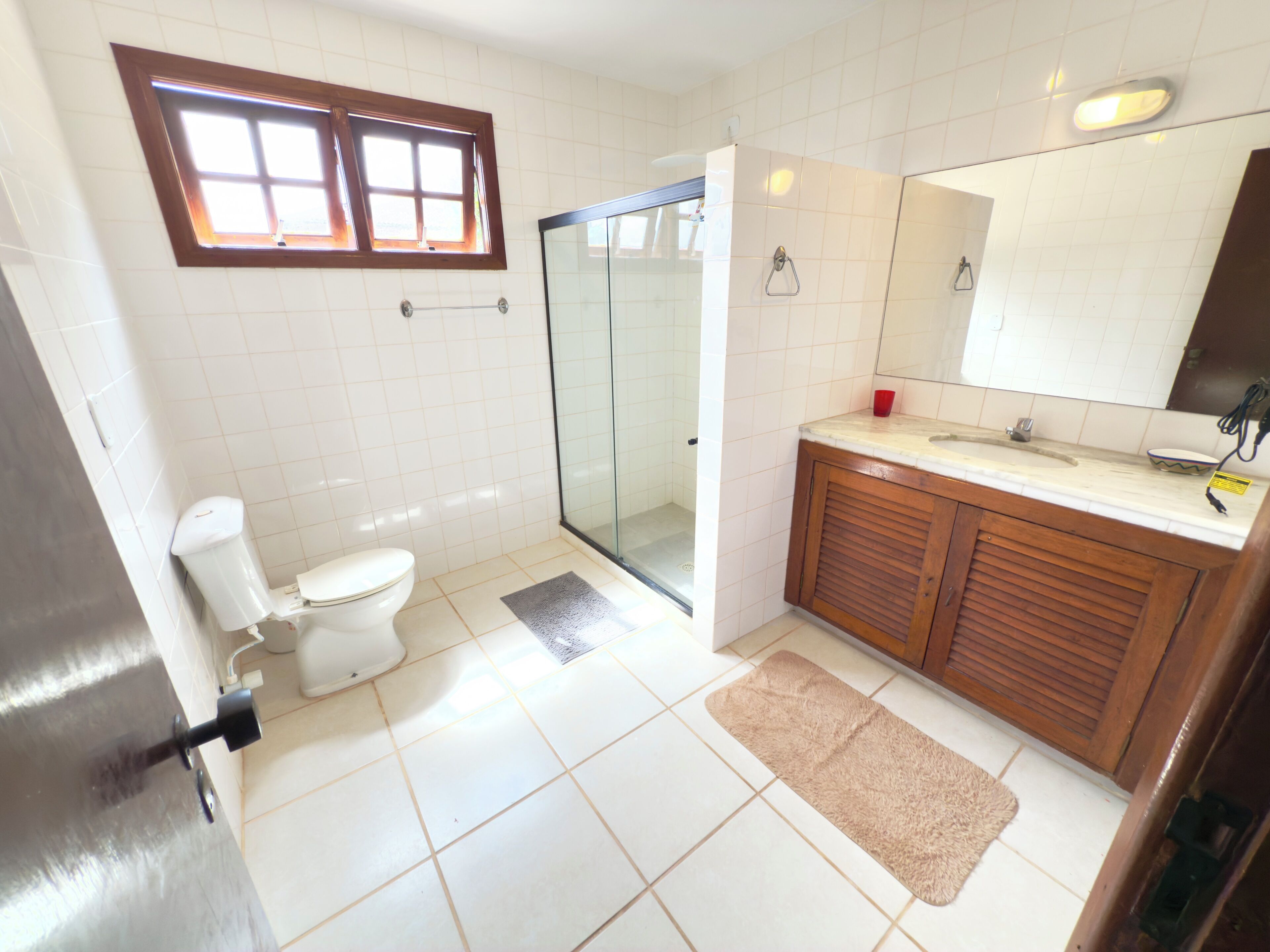 A bathroom with a toilet, shower, and sink.