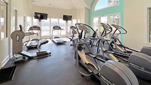 A gym with treadmills, ellipticals, and a stationary bike.