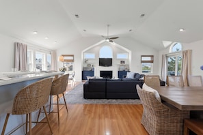 A spacious living area with a large sofa, dining table, and bar seating.