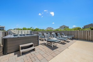 An outdoor patio with a built-in grill and multiple lounge chairs. - 7BR house with pickleball lines & net (Corolla)