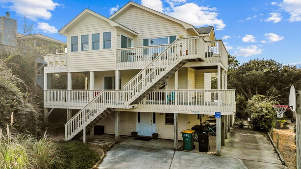 A two-story house with a balcony, a staircase, and a basketball hoop.