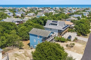 A residential area with houses, a beach, and a clear sky.