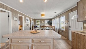 A spacious kitchen with a large island, wooden cabinetry, and pendant lighting. - KDN1819: The Duck Walk, Oceanview | Crow's Nest Deck | W/D (Kill Devil Hills)