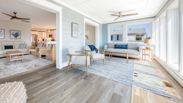 A spacious living room with a large window, a ceiling fan, and a view of the outside.