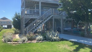 A two-story building with a wooden deck and a staircase leading to the upper level.
