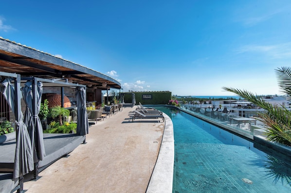 Una piscina al aire libre, sillones reclinables de piscina