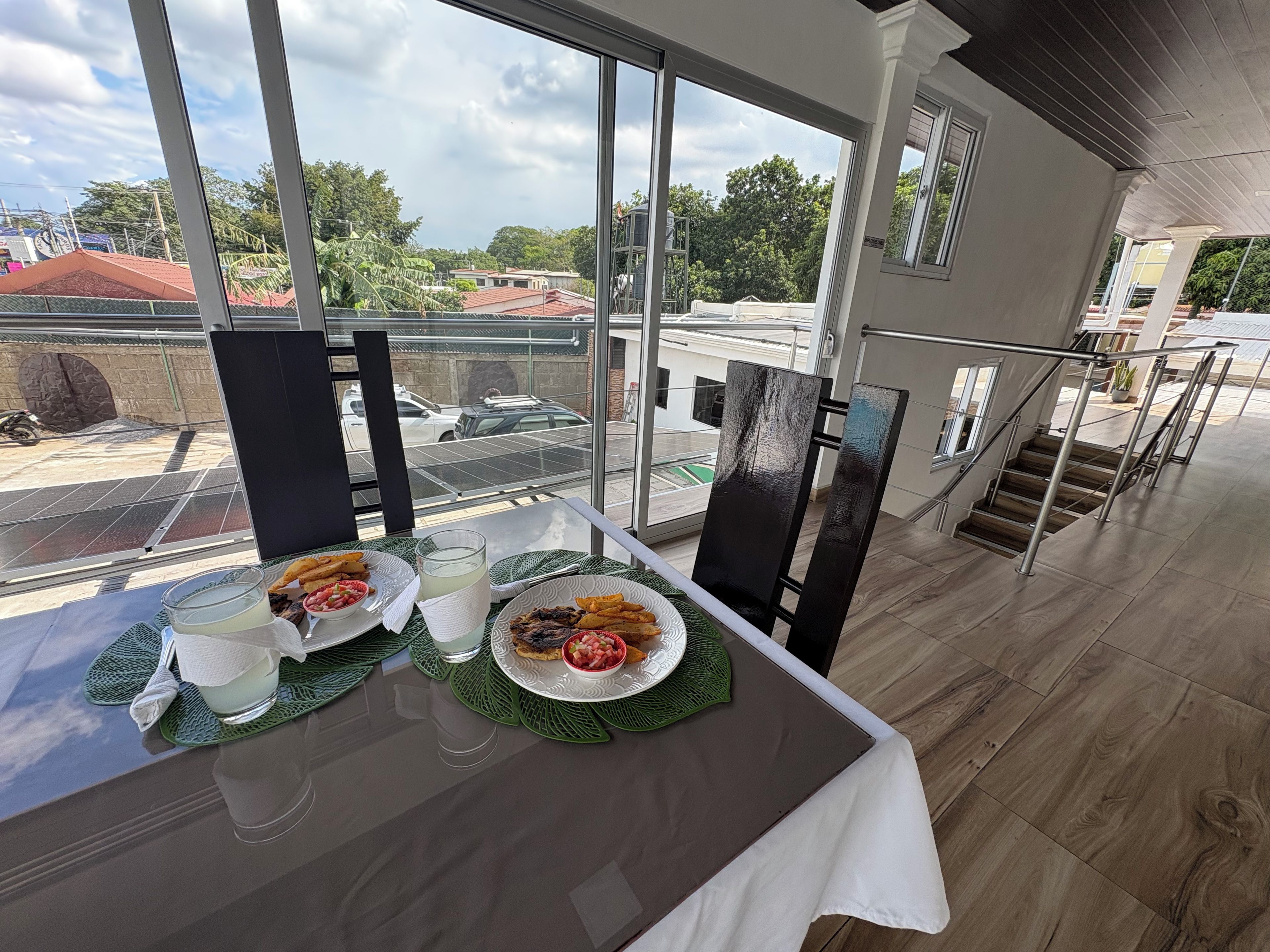 A dining area with a table set for two, a glass of water, and a plate of food.