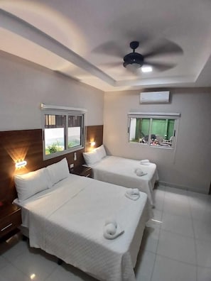 A hotel room with two beds, a ceiling fan, and windows with curtains. - Hostal Boutique Isabel (Ticuantepe)