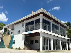 A modern two-story building with a covered entrance, large windows, and a balcony. - Hostal Boutique Isabel (Ticuantepe)