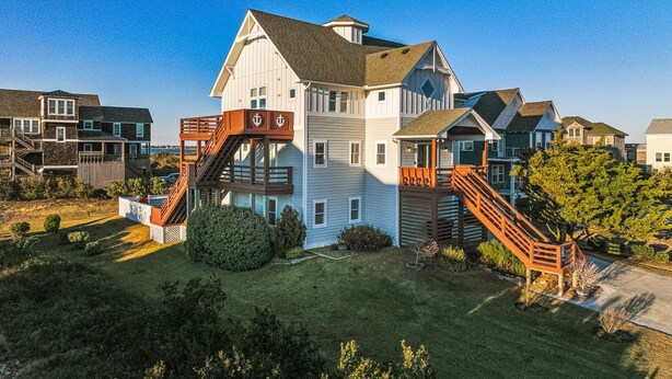 A two-story house with a wooden staircase and a small deck.