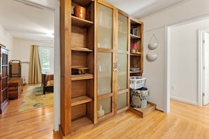 A room with wooden shelving, a basket, and a door leading to another room. - Tranquil 4BR Waterview | Fireplace | Deck (Southern Shores)