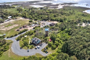 Luchtbeeld van een resort met een kronkelende weg, parkeerplaats en gebouwen, omringd door dicht bos.