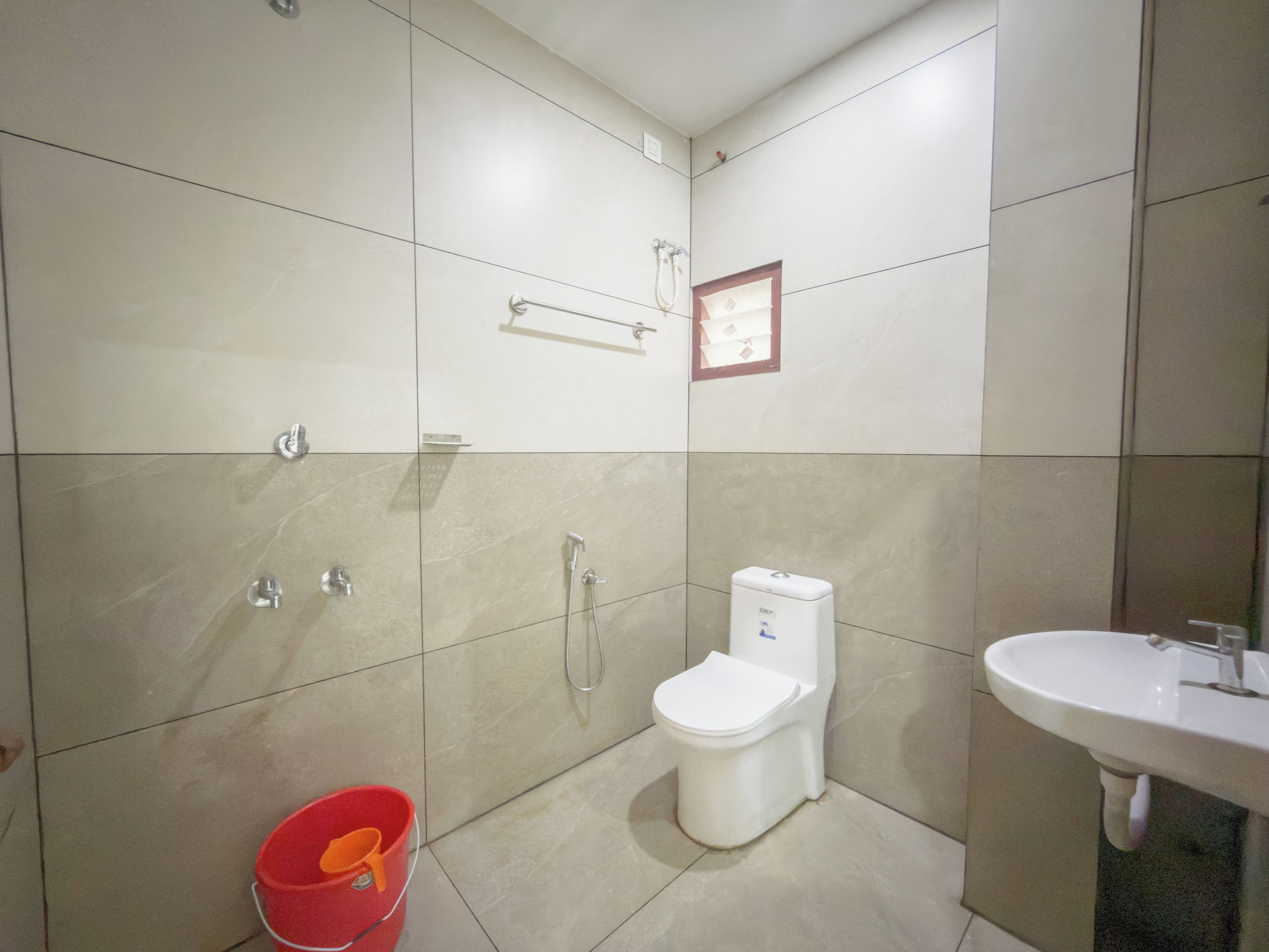 A bathroom with a toilet, bidet, shower, and sink.