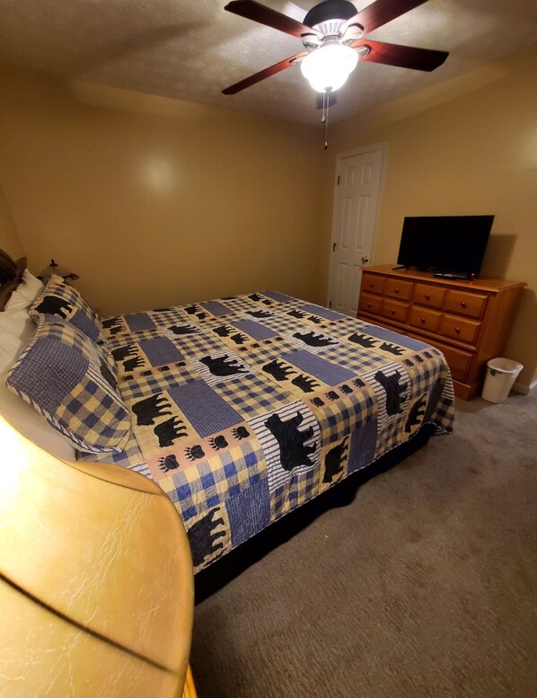 A bedroom with a bed, a dresser, a ceiling fan, and a television. - Serene Mountain Chalet Retreat (Gatlinburg)