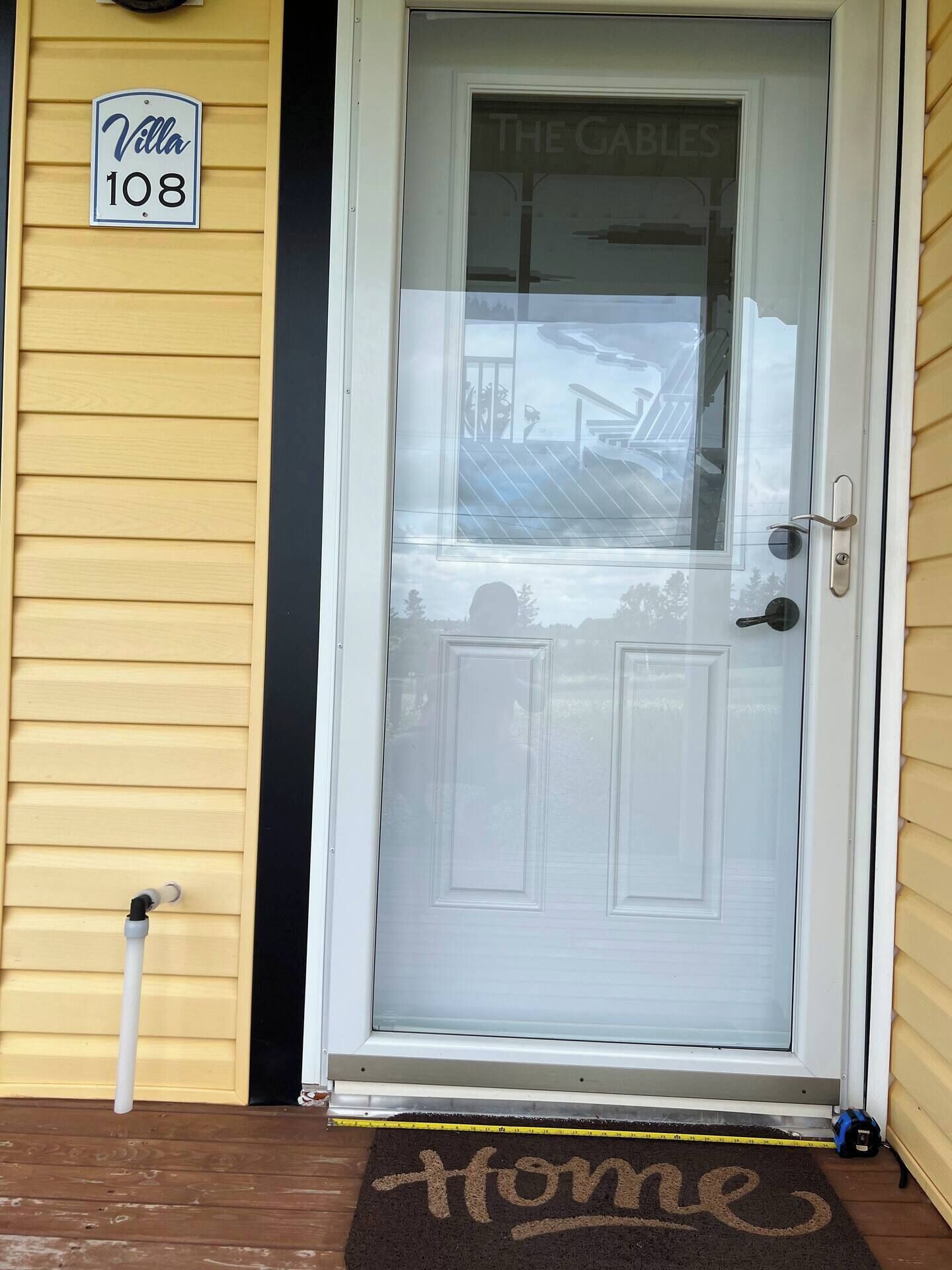 A front door with a frosted glass panel, a 'Villa 108' sign, and a 'The Gables' sign above the door.