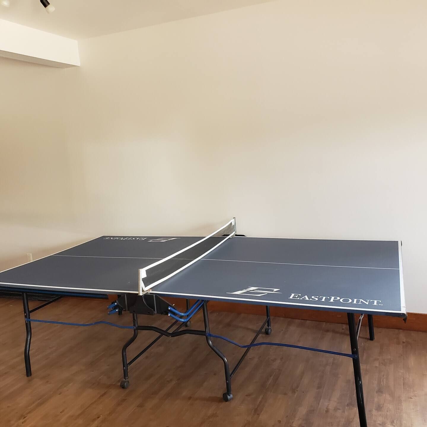 Ett bordtennisbord med en vit kant och varumärket ”EASTPOINT” på framsidan.