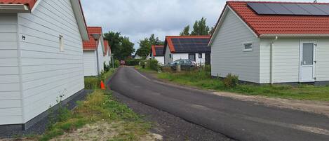 A row of single-story houses with red-tiled roofs and solar panels.