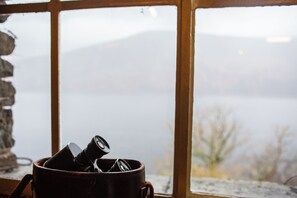A rustic cabin with a window overlooking a lake and mountains. - Haweswater Hotel (Penrith)