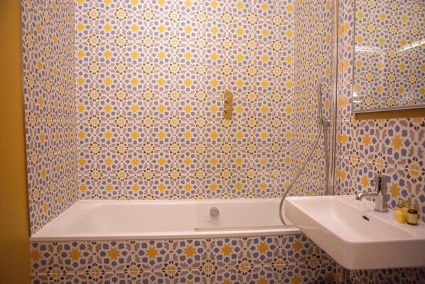 Ein Badezimmer mit Badewanne, Waschbecken und Spiegel.