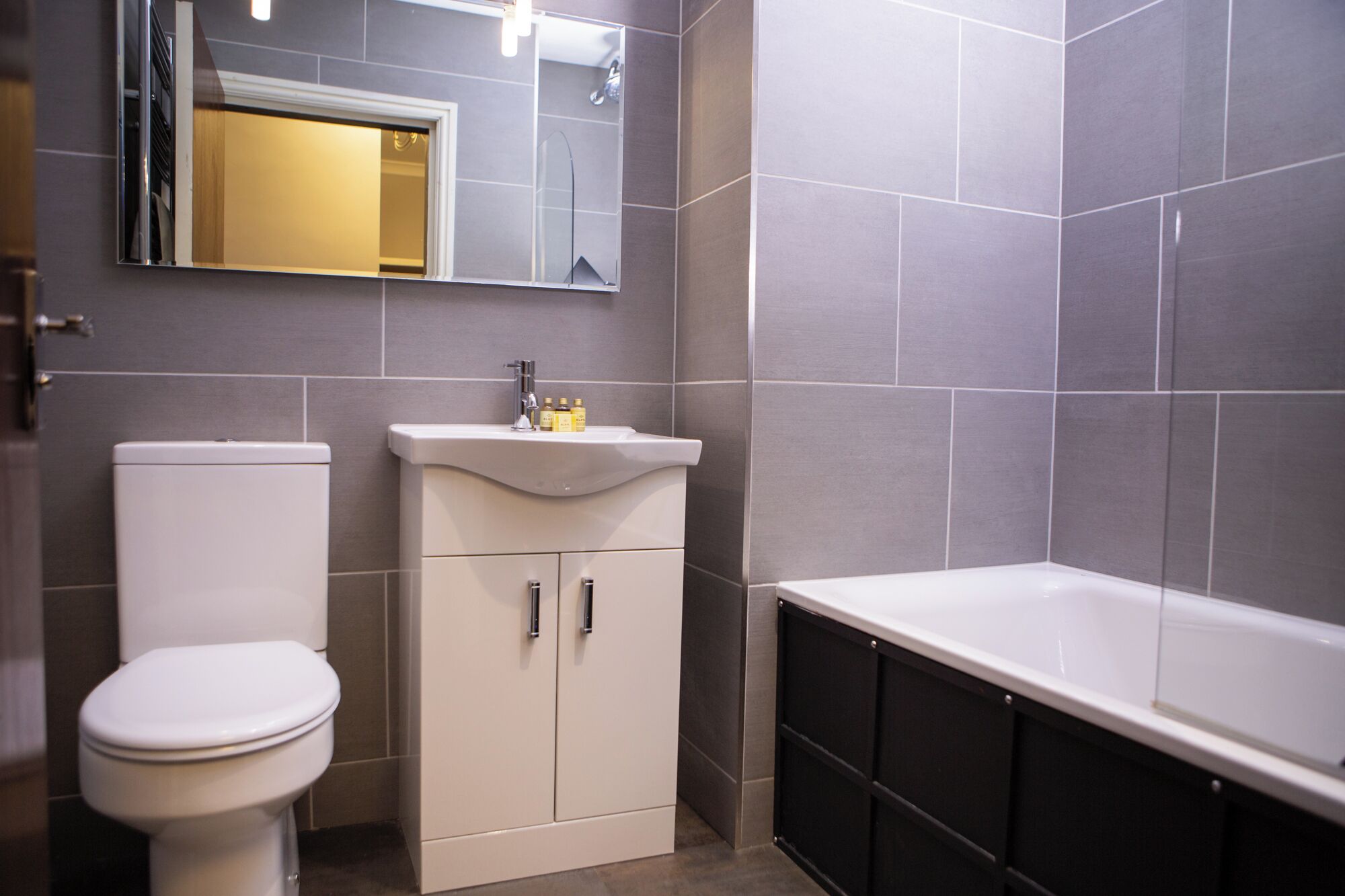 A modern bathroom with a toilet, sink, and bathtub.
