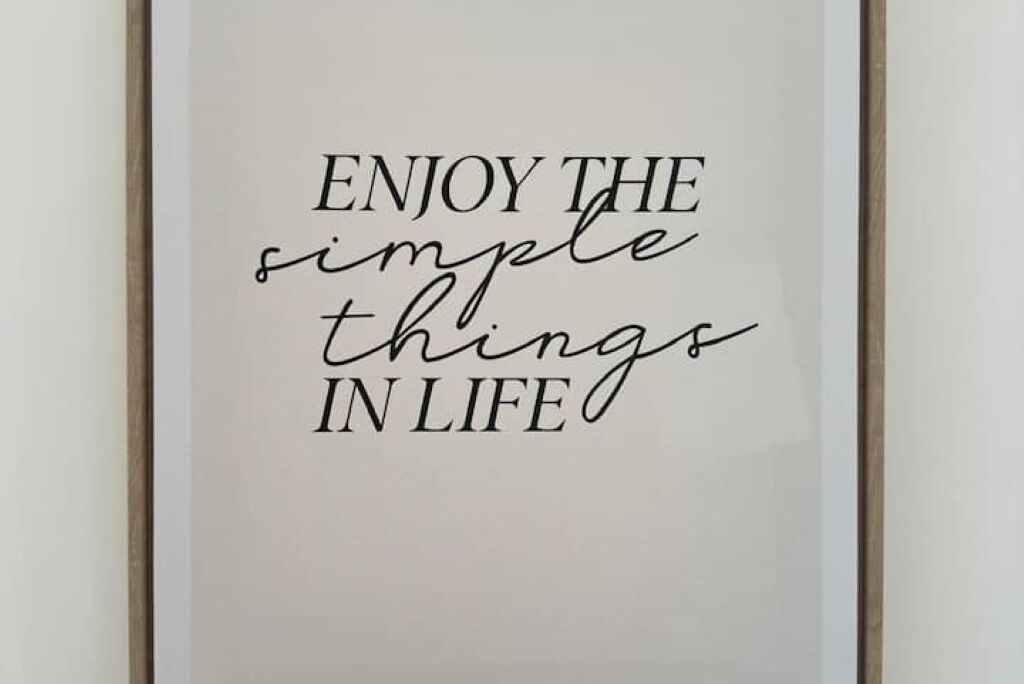 A framed quote saying "ENJOY THE simple things IN LIFE" on a white background.