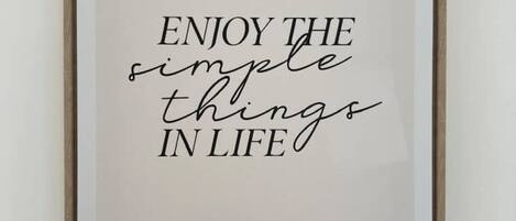 A framed quote saying "ENJOY THE simple things IN LIFE" on a white background.