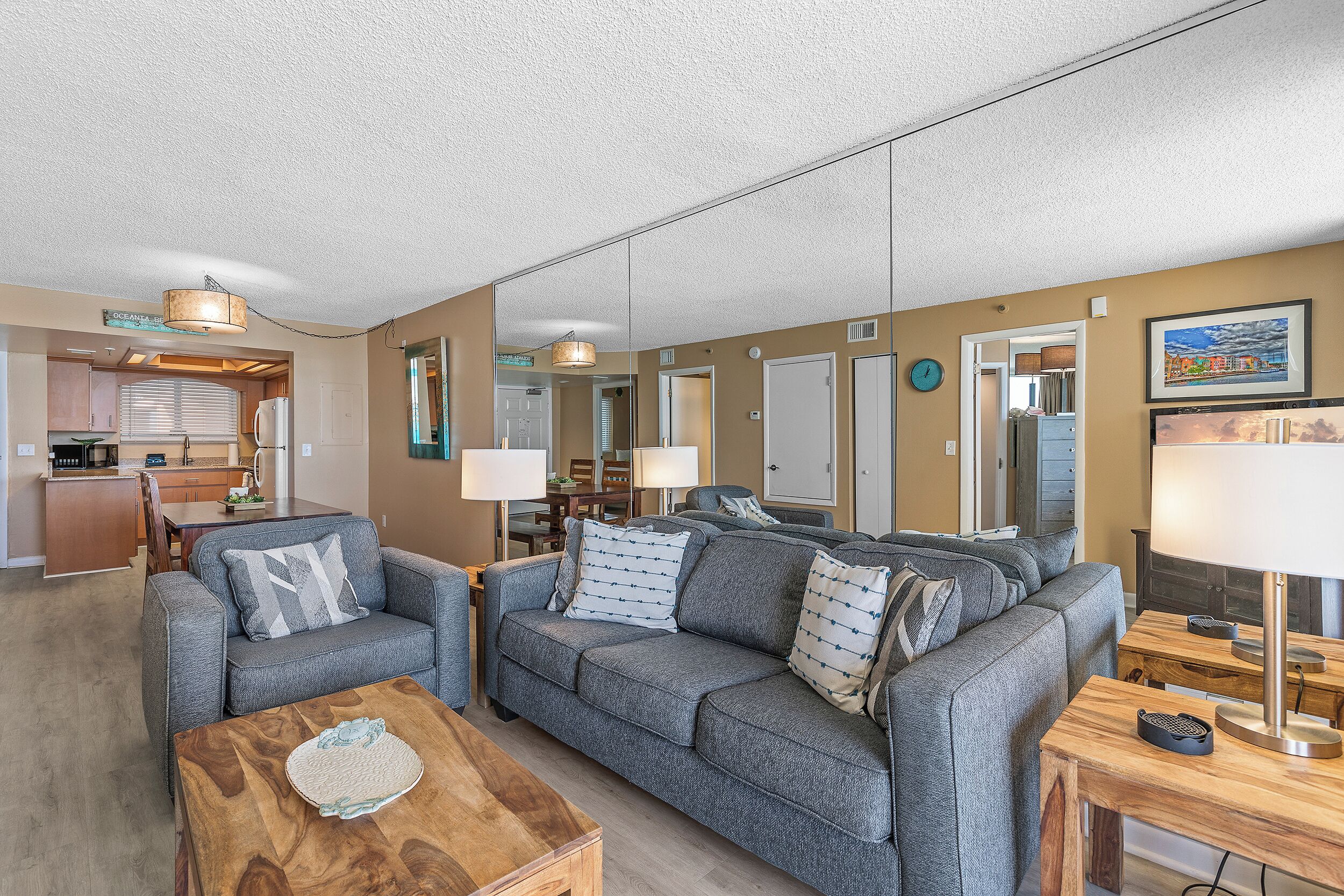 A living room with a sofa set, a coffee table, and a dining area with a table and chairs.