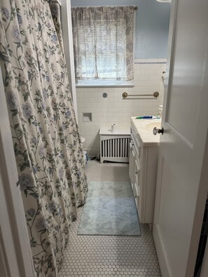 A bathroom with a toilet, sink, and shower area. - Convenient, Quiet Ryder Cup Location 3-bedroom house in Amityville (Amityville)