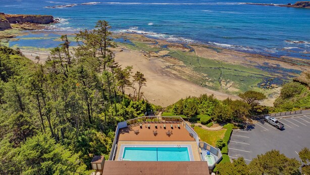 A pool area with a view of the ocean and beach. - Romantic Ocean-View Suite with King Bed (Otter Rock)