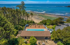 A pool area with a view of the ocean and beach.