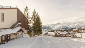 Ein schneebedecktes Skigebiet mit einem Gebäude, auf dem „LEVNOISE“ steht, und einem Schild für „INTERSPORT“.