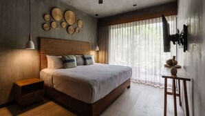 A bedroom with a bed, bedside tables, a ceiling fan, and a window with curtains.