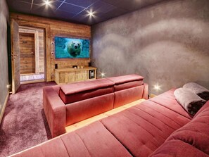 Ein gemütliches Zimmer mit einem großen Fenster, einem Holzschrank und einem roten Sofa.