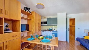 Un espai vital compacte amb zona de menjador, petita cuina i àrea d'estar.